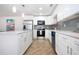 Stylish kitchen featuring stainless steel appliances, white cabinets, and an elegant backsplash at 1902 Andover St # 198, Sun City Center, FL 33573
