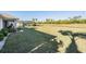 Spacious backyard with expansive lawn, screened pool enclosure, mature trees, and water view at 2335 E Del Webb Blvd, Sun City Center, FL 33573