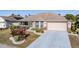 Well-manicured front yard featuring colorful shrubs, an attached two-car garage, and a screened-in porch at 2335 E Del Webb Blvd, Sun City Center, FL 33573