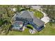 Beautiful aerial view of a home, showcasing its pool, patio, fire pit area, manicured lawn and lush surroundings at 27625 Lincoln Pl, Wesley Chapel, FL 33544