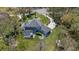 Beautiful aerial view of a home, showcasing its pool, patio, fire pit area, manicured lawn and lush surroundings at 27625 Lincoln Pl, Wesley Chapel, FL 33544