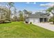 Spacious backyard with lush green grass, a storage shed, and a view of the home's garage and screened patio at 27625 Lincoln Pl, Wesley Chapel, FL 33544