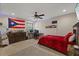 Spacious bedroom with a red comforter, ceiling fan, and a desk area with a computer for work or gaming at 27625 Lincoln Pl, Wesley Chapel, FL 33544