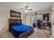 A bedroom with a blue comforter, and a corner desk set up for gaming and work at 27625 Lincoln Pl, Wesley Chapel, FL 33544