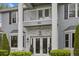 Elegant home featuring a striking facade, double-door entry, and a charming upper-level balcony, complemented by manicured greenery at 27625 Lincoln Pl, Wesley Chapel, FL 33544