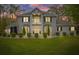 Charming two-story home at dusk featuring a balcony, bay windows, manicured lawn, and a landscaped front yard at 27625 Lincoln Pl, Wesley Chapel, FL 33544