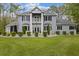 Charming two-story home with a manicured lawn, elegant columns, and beautiful landscaping at 27625 Lincoln Pl, Wesley Chapel, FL 33544