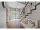 Inviting foyer with wood floors, staircase, bench seating, and front door with glass panels at 27625 Lincoln Pl, Wesley Chapel, FL 33544