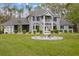 Elegant gray home with a manicured front lawn, fountain, and mature landscaping, providing a serene and inviting setting at 27625 Lincoln Pl, Wesley Chapel, FL 33544