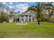 Beautiful landscaped yard featuring a large fountain, palm trees, and a well-maintained lawn in front of the gray home at 27625 Lincoln Pl, Wesley Chapel, FL 33544