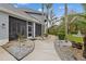 Covered patio with wicker furniture, offering a relaxing outdoor living space with views of the beautifully landscaped yard at 27625 Lincoln Pl, Wesley Chapel, FL 33544