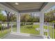 Covered porch with white railings and a clear view of the front yard at 27625 Lincoln Pl, Wesley Chapel, FL 33544