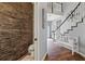 Chic powder room with stacked stone wall accents that leads to the main foyer with staircase at 27625 Lincoln Pl, Wesley Chapel, FL 33544