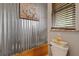 Industrial style powder room features corrugated metal wall and a unique hand washing station at 27625 Lincoln Pl, Wesley Chapel, FL 33544