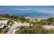 Serene aerial view showcasing waterfront access with a sandy beach next to a quiet neighborhood street at 314 Ontario Ave, Crystal Beach, FL 34681