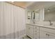 Bright bathroom featuring double sinks, modern fixtures, and a shower with patterned curtain at 314 Ontario Ave, Crystal Beach, FL 34681