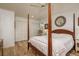 Bright bedroom featuring a four-poster bed, ceiling fan, and wood-look flooring at 314 Ontario Ave, Crystal Beach, FL 34681