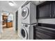 Modern laundry room with stacked washer and dryer and dark cabinets, located near the kitchen at 3301 Bayshore Blvd # 1508B, Tampa, FL 33629