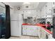 Kitchen with white cabinets, colorful backsplash, tile floor, and modern appliances at 4152 56Th N Way # 614, Kenneth City, FL 33709