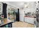 Kitchen area with sliding glass doors to an enclosed patio, tile floors, and white cabinets at 4152 56Th N Way # 614, Kenneth City, FL 33709