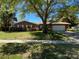 Charming single-story brick home with a well-manicured lawn and mature shade tree at 504 Carriage Hills Dr, Temple Terrace, FL 33617