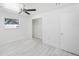 Bright bedroom with light gray wood-look floors, ceiling fan, and closet at 509 13Th Nw Ave, Largo, FL 33770