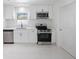 Modern kitchen featuring stainless steel appliances, white cabinetry, and new flooring at 509 13Th Nw Ave, Largo, FL 33770