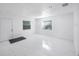 Spacious, well-lit living room with modern tile floors, neutral tones, and two bright windows at 509 13Th Nw Ave, Largo, FL 33770