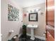 Charming powder room featuring marble floors, a pedestal sink, and decorative wall art at 550 7Th S St, Safety Harbor, FL 34695