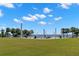 Scenic waterfront park with picnic tables, walking paths, and palm trees under a bright, cloudy sky at 550 7Th S St, Safety Harbor, FL 34695