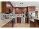 Well-equipped kitchen featuring custom dark wood cabinets, granite countertops, and stainless-steel appliances for modern convenience at 550 7Th S St, Safety Harbor, FL 34695