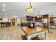Open floor plan with kitchen, dining area, and living room, accented by travertine tile, natural light, and high-end finishes at 550 7Th S St, Safety Harbor, FL 34695