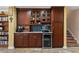 Custom wet bar featuring built-in cabinetry, a wine refrigerator, a sink, granite countertops, and display shelves at 550 7Th S St, Safety Harbor, FL 34695