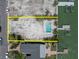 Aerial view of a waterfront lot with a pool, dock, and room to build at 575 Crystal Dr, Madeira Beach, FL 33708