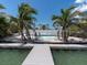 Inviting backyard pool area featuring a wooden dock and lush tropical landscaping at 575 Crystal Dr, Madeira Beach, FL 33708
