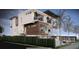 Modern three-story home with balconies and lush green hedges along waterfront at 575 Crystal Dr, Madeira Beach, FL 33708