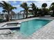 Inviting waterfront pool and jacuzzi featuring a modern design surrounded by lush tropical landscaping at 575 Crystal Dr, Madeira Beach, FL 33708