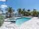 Outdoor pool with an adjacent spa and a waterfront view, surrounded by pavers and palm trees at 575 Crystal Dr, Madeira Beach, FL 33708