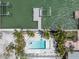 Aerial view of waterfront lot with a swimming pool, spa, dock, and lush tropical landscaping at 575 Crystal Dr, Madeira Beach, FL 33708