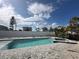 View of the backyard pool area and the neighboring homes from the edge of the property at 575 Crystal Dr, Madeira Beach, FL 33708