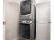 Modern, stacked washer and dryer unit, with a white door at 672 Spring Lake Cir, Tarpon Springs, FL 34688