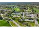 Panoramic aerial view showcasing the tennis courts, golf course, surrounding homes, and lush landscaping at 6762 Pearleaf Ct, Spring Hill, FL 34606