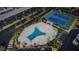 Overhead view of community pool, lounge area and tennis court with landscaping and parking at 7645 Sun Island S Dr # 201, South Pasadena, FL 33707