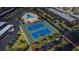 Overhead view of a tennis court and a pool area with ample parking nearby at 7645 Sun Island S Dr # 201, South Pasadena, FL 33707