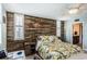 Bright bedroom featuring a unique wood accent wall, ceiling fan, and light-filled bathroom entrance at 7645 Sun Island S Dr # 201, South Pasadena, FL 33707