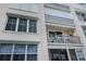 Exterior view of the condo building with balcony, hurricane shutters and patio furniture at 7645 Sun Island S Dr # 201, South Pasadena, FL 33707