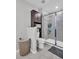 Bathroom featuring a walk-in shower with glass doors and a cabinet for storage at 8512 Reedville St, New Port Richey, FL 34654