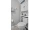Compact bathroom featuring a toilet, cabinet, and shelf, designed for functionality at 8512 Reedville St, New Port Richey, FL 34654