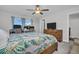 Well-lit bedroom with two desks, a bed, and a dresser beneath a television at 8512 Reedville St, New Port Richey, FL 34654