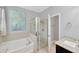 Bathroom featuring a soaking tub with tile surround and glass-enclosed shower at 867 Vino Verde Cir, Brandon, FL 33511